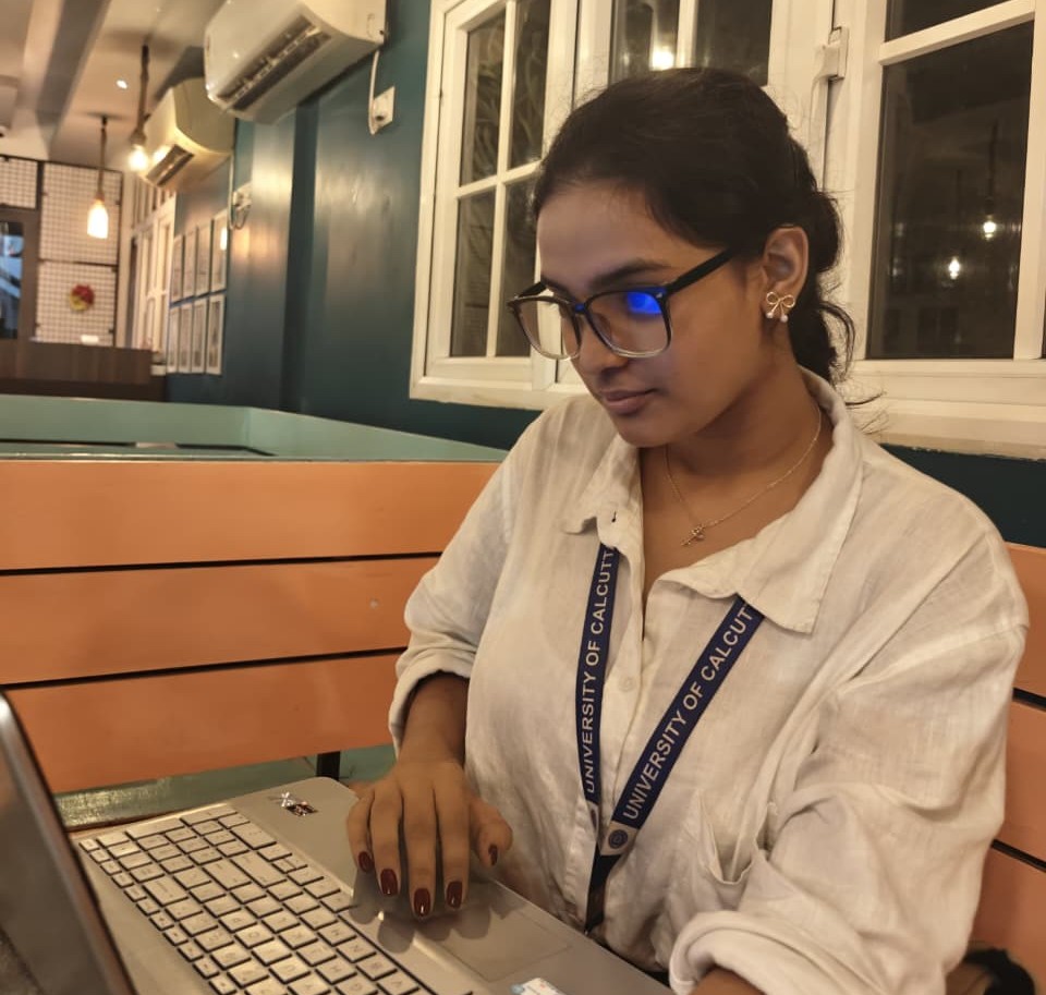 Ayushi working on a laptop at a cafe